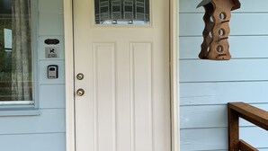 A white door with a peephole and a small window above it.