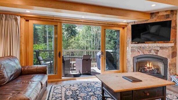 A cozy living room with a leather sofa, a coffee table, and a fireplace.