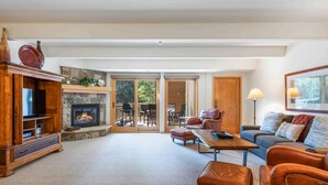 A spacious living room with a fireplace, leather furniture, and a stone accent wall. - Lodge at Lionshead 204 (Vail)