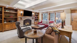 A cozy living room with a fireplace, a television, and a comfortable seating area. - Lodge at Lionshead 208 (Vail)