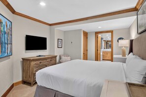 Une chambre d’hôtel avec un lit, une commode, une télévision et un tableau accroché au mur.