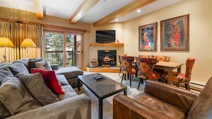 A modern living room with a fireplace, comfortable seating, and a television. - Lodge at Lionshead 250B (Vail)