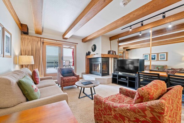Una sala de estar acogedora con chimenea, televisor y asientos cómodos.