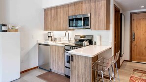 Une cuisine moderne équipée d’un four à micro-ondes, d’une cuisinière et d’un lave-vaisselle intégrés.