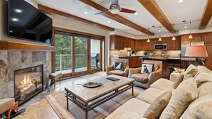 A spacious living room with a fireplace, a large flat-screen TV, and a comfortable seating area. - Lodge at Lionshead 360 (Vail)
