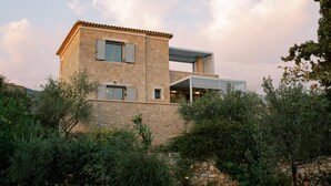 A stone building with a flat roof, a balcony, and a window with shutters. - Riglia Villas - Villa Olive (West Mani)