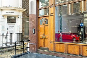 Traditional entrance with a glass panel and NEWS & COFFEE sign.