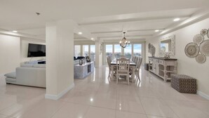 A spacious living area with a dining table, a sofa, and a TV.