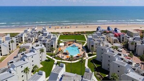 A resort with a central pool, beach access, and a view of the ocean.