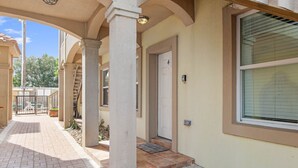 A covered outdoor area with a tiled floor, a door, and a window with blinds. - Ground Floor Beach Side 2Min Walk To The Beach SF (South Padre Island)
