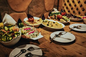 Enjoy a diverse selection of cuisine at this communal dining table, set with a variety of dishes and fine tableware.