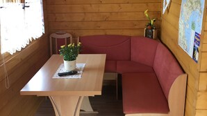 L’intérieur d’un chalet en bois, avec une table, un banc et une carte accrochée au mur.