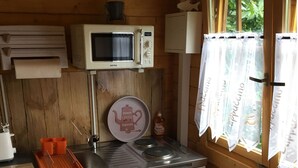 Une cuisine compacte équipée d’un four à micro-ondes, d’une machine à café et d’un évier.