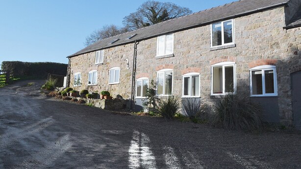A stone building with multiple windows and a gravel driveway. - 2 bedroom accommodation in Oswestry (Oswestry)