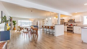 A modern kitchen with wooden flooring, white cabinets, and a central island. - Bridger Hawk Duplex (NEW) (Bozeman)