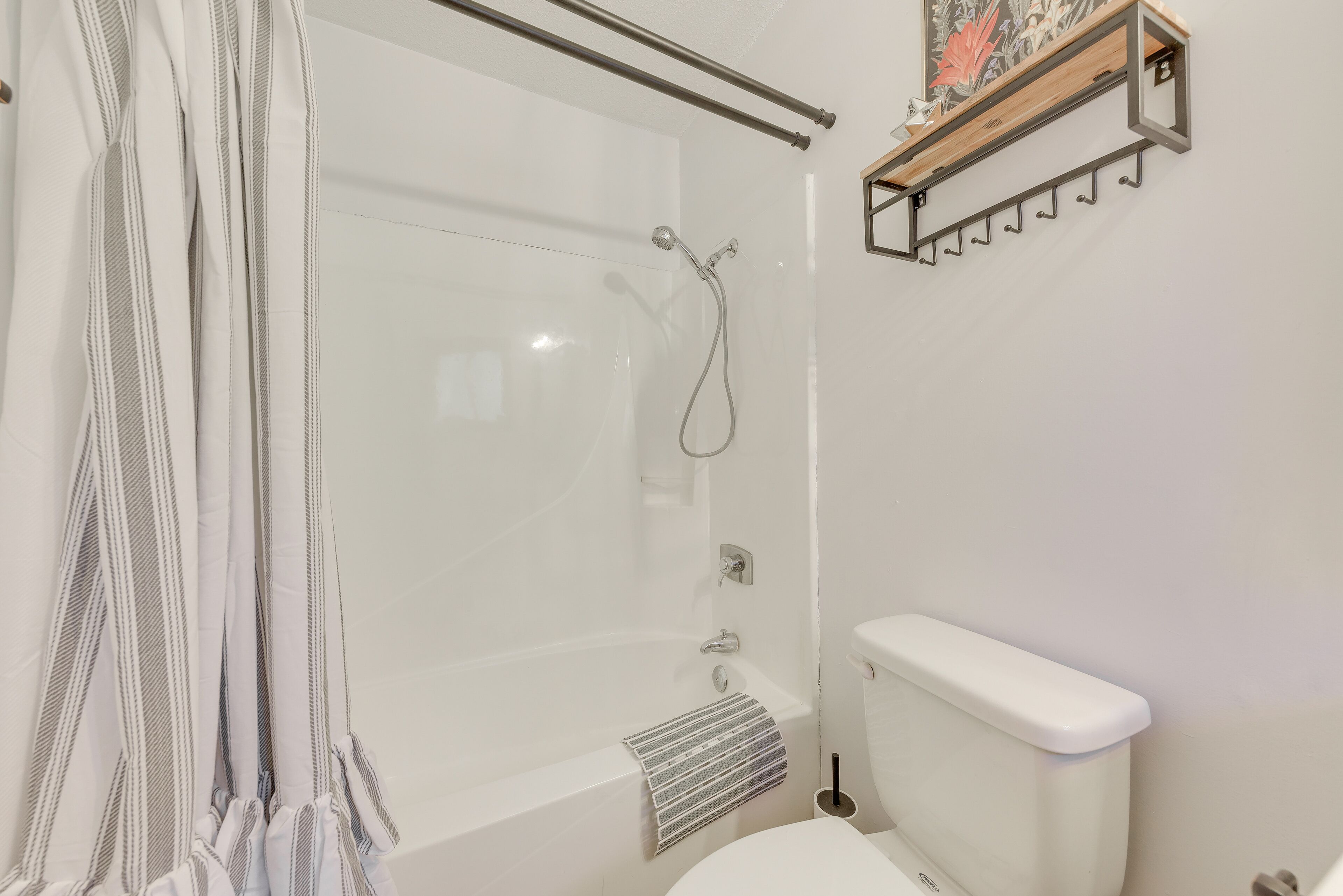 A bathroom with a glass shower enclosure, a white toilet, and a towel rack.