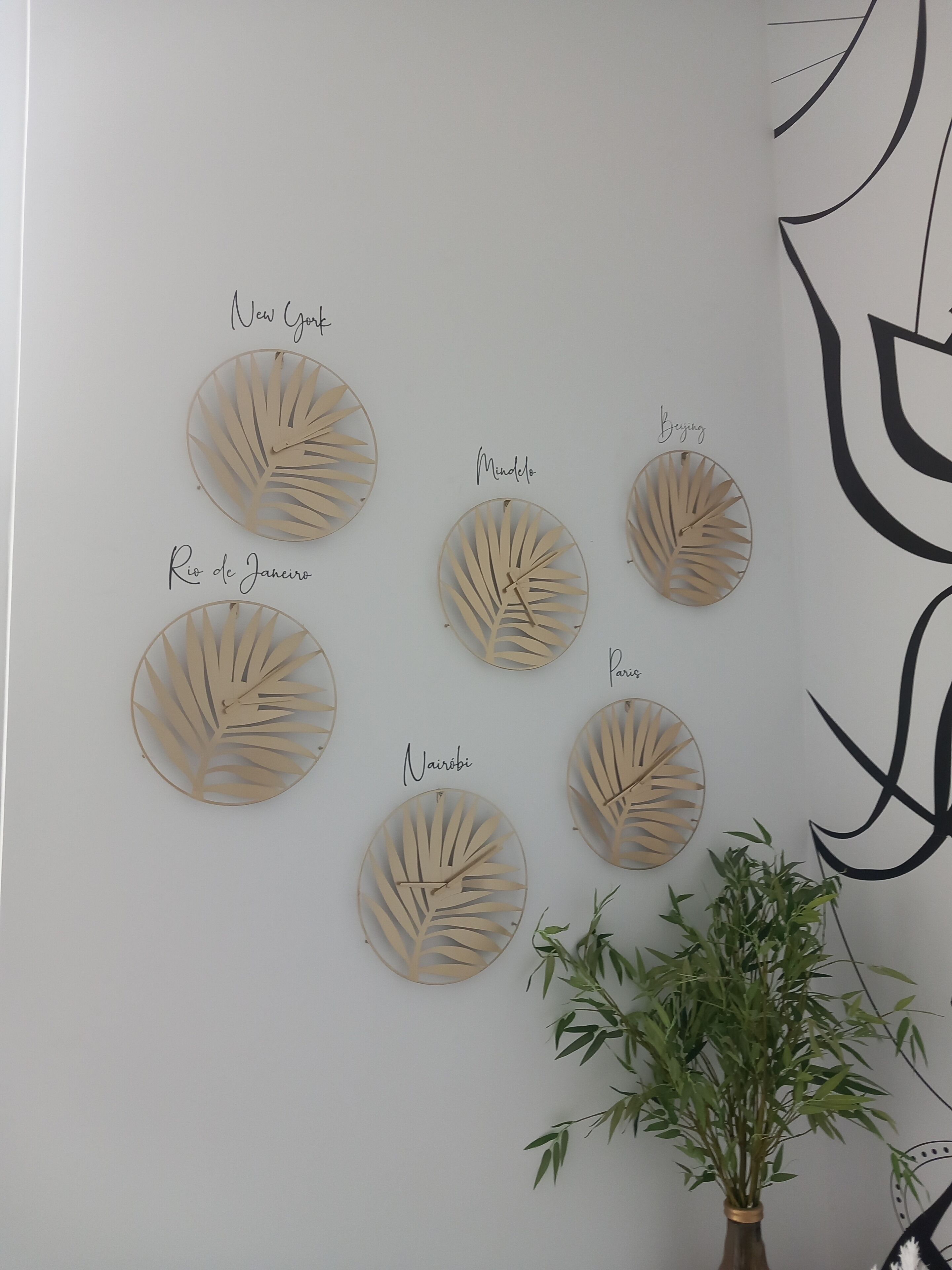 Een muur met zes ronde, bladachtige decoraties, elk voorzien van een plaatsnaam.
