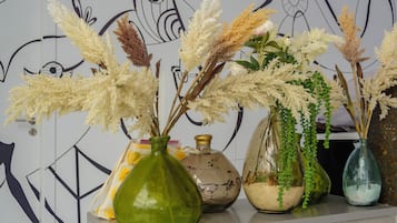 A variety of vases with dried plants on a shelf.