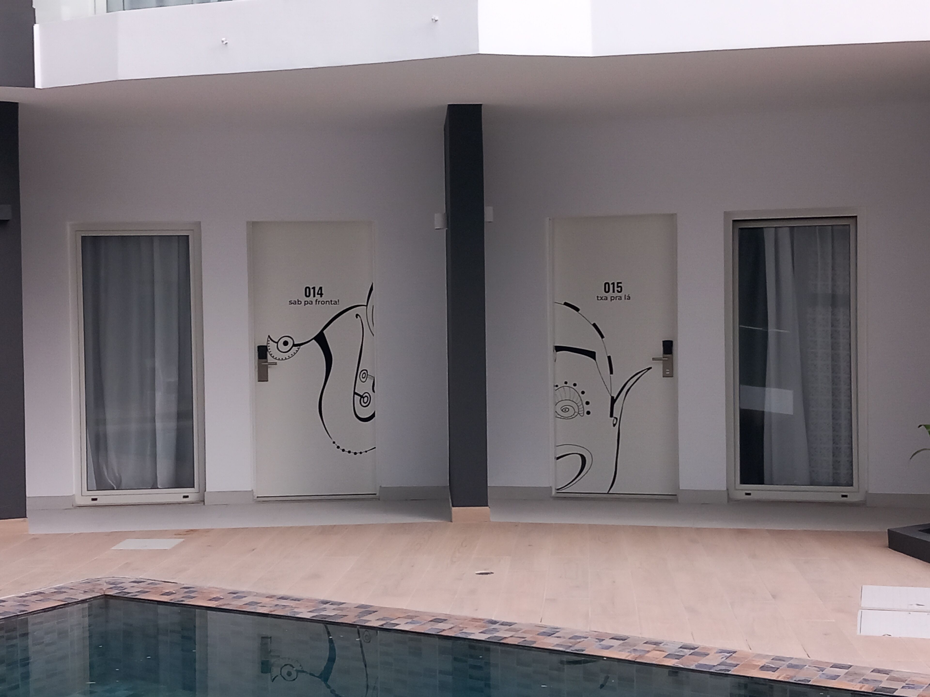 A modern building with three doors, each with a unique black design.