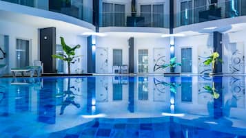 Relax by the central pool in a spacious, well-designed lobby with seating areas and lush greenery.