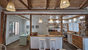 A rustic kitchen with wooden beams, a central island with stools, and hanging pendant lights. - Casa Tarif - Bolonia Beach Campus, your beach house in Bolonia - Tarifa (Tarifa)