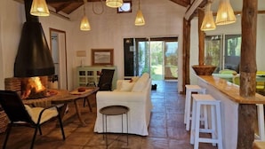 A cozy interior with a fireplace, wooden beams, and hanging light fixtures. - Casa Tarif - Bolonia Beach Campus, your beach house in Bolonia - Tarifa (Tarifa)