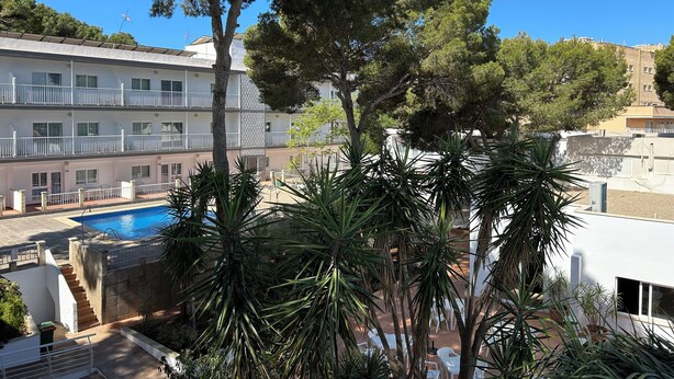 Ein Hotel mit Pool, Außenbereich und Blick auf die umliegenden Gebäude.