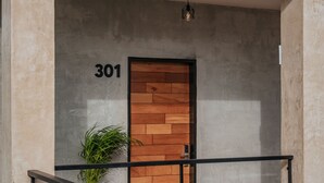 A modern building with a numbered door, a staircase, and a potted plant. - Hotel Casa 57 (Mérida)