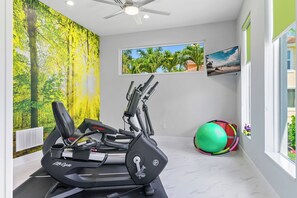 A home gym with a treadmill, stationary bikes, and a yoga ball. - Villa4dreamers - The ultimate dream on the Gulf of Mexico. (Cape Coral)