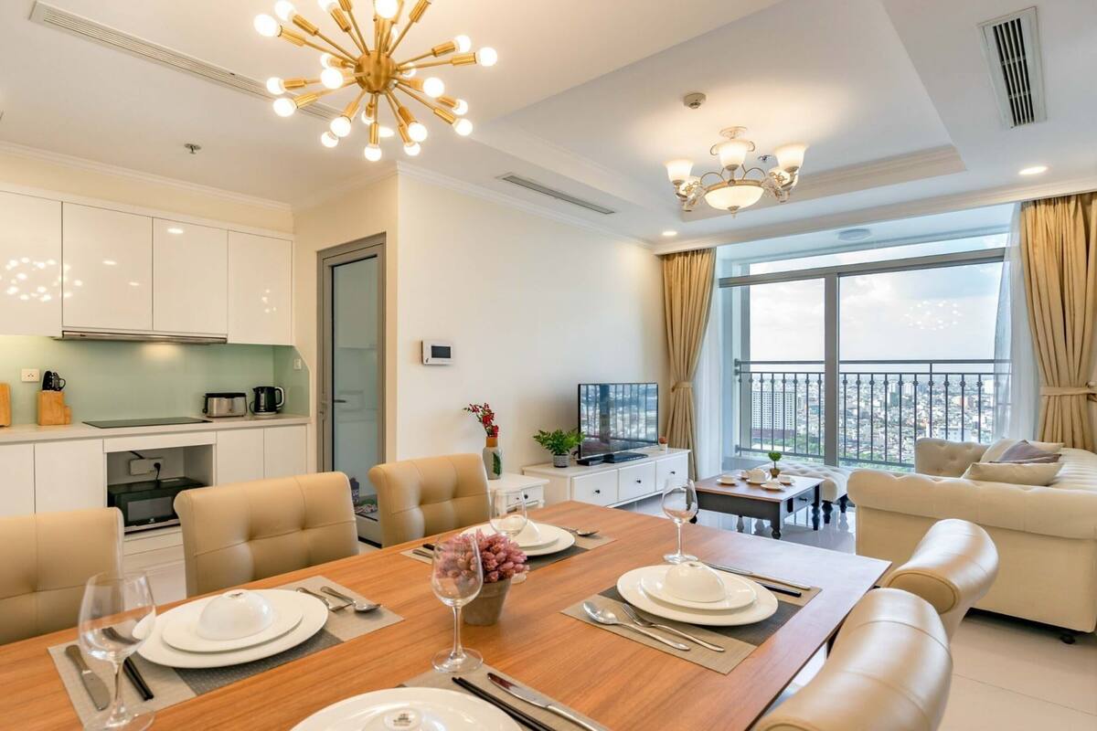 Ein modernes Wohnzimmer mit Essbereich, einer Küche und einem Balkon mit Blick auf die Stadt.