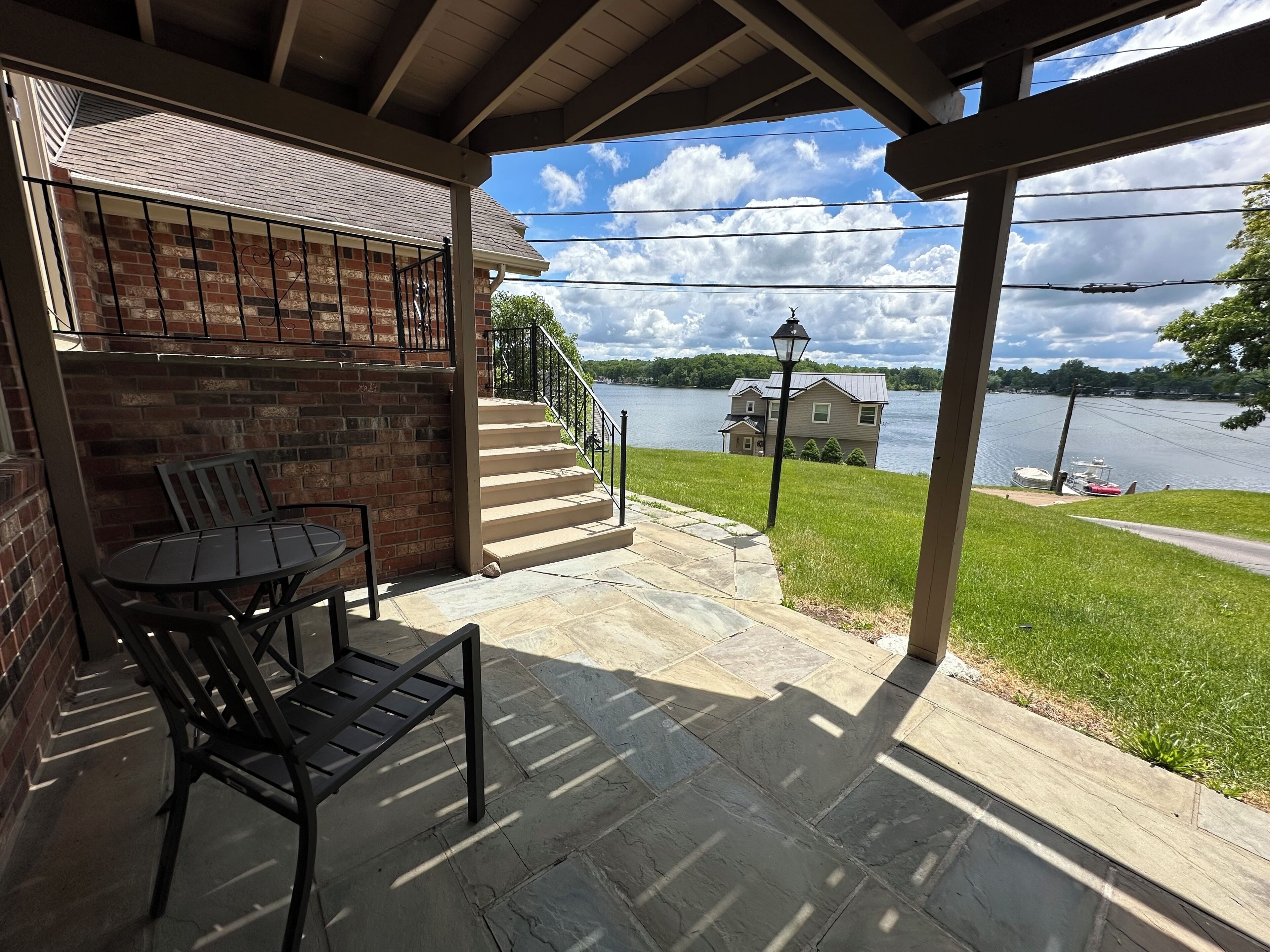 Patio with a bistro set in the shade of the upper deck