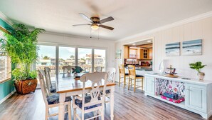 A spacious dining area with a high ceiling fan, a large potted plant, and a view of the outdoors. - Private Pool & Dock: Old Florida Waterfront Home (Hernando Beach)