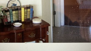 A room with a wooden desk, a framed portrait, and a door leading to another room. - Sailor's Choice - NON SMOKING Apartment in Downtown Cedar Key with Gulf Views!
 (Cedar Key)