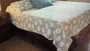 A bedroom with a bed, a ceiling fan, a nightstand, a lamp, a framed picture, and a window. - Sailor's Choice - NON SMOKING Apartment in Downtown Cedar Key with Gulf Views!
 (Cedar Key)