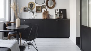 Et moderne køkken med spiseplads, der indeholder et rundt bord, en stol og en hængende lampe.