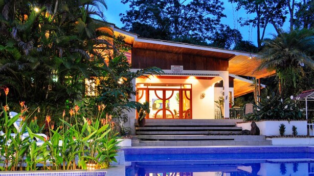 Une maison moderne dotée d’une piscine, entourée d’une végétation luxuriante.