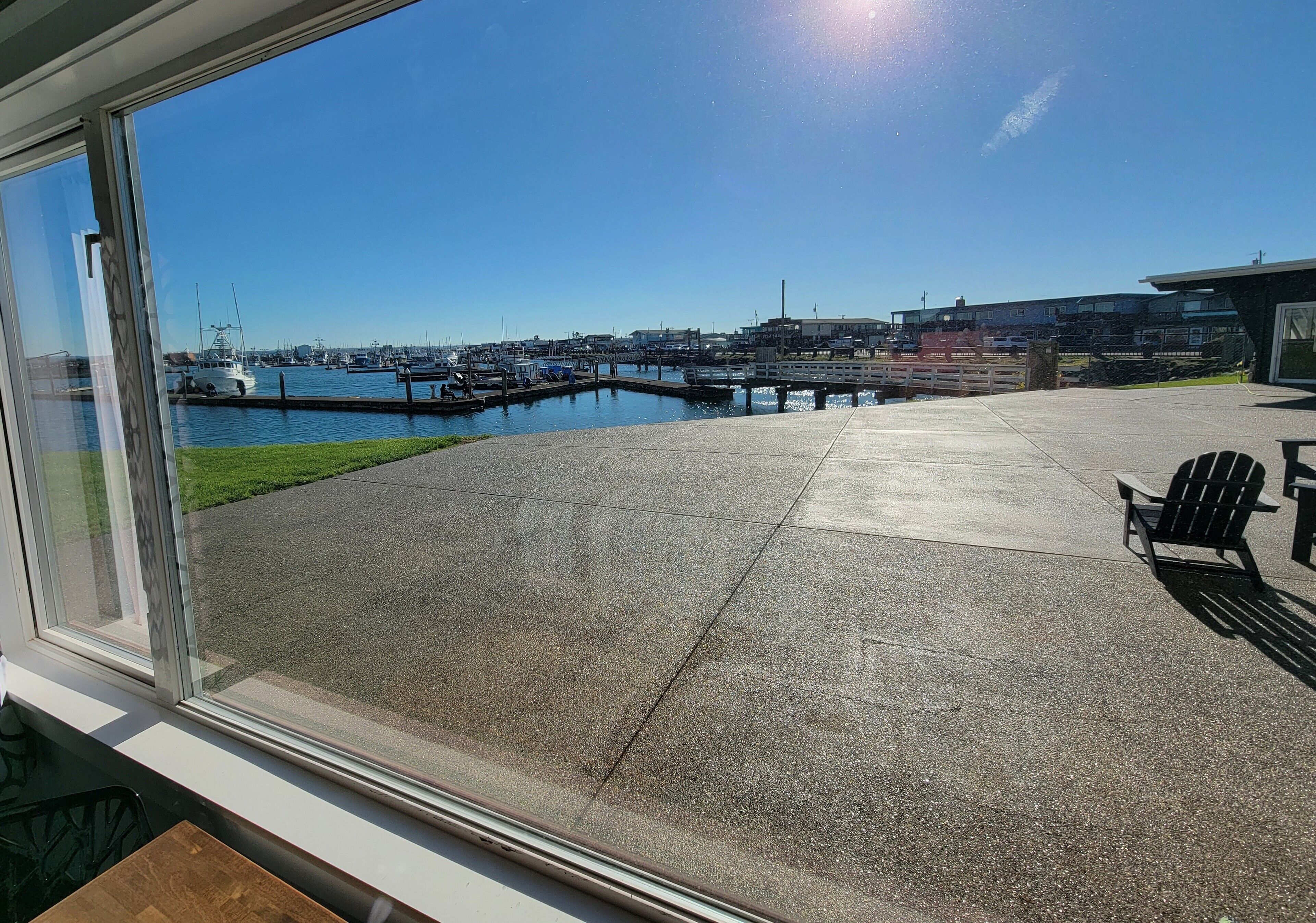 Un patio con vista a un puerto deportivo, una terraza de concreto y una silla.