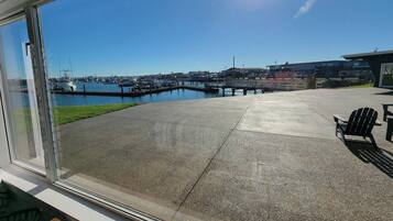 Un patio con vista a un puerto deportivo, una terraza de concreto y una silla.
