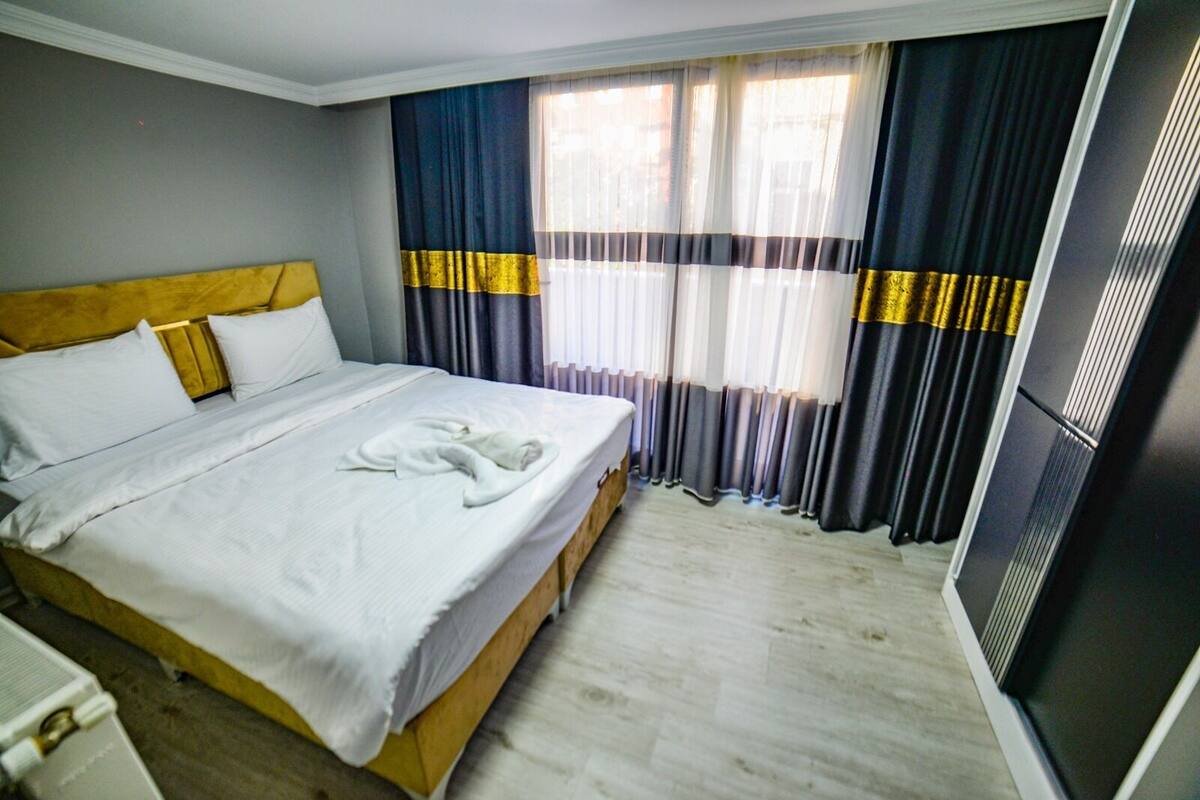 Una habitación de hotel con cama, cortinas y ventana.