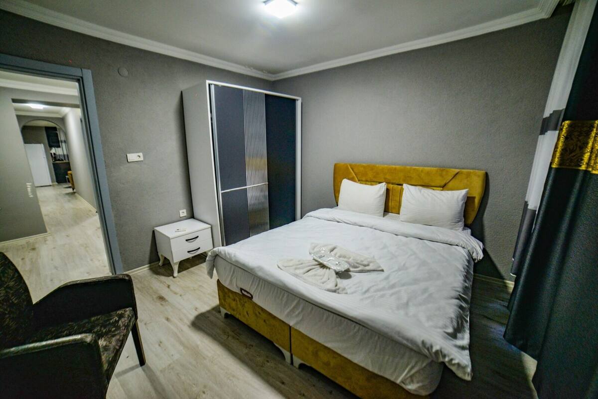 Una habitación de hotel con cama, mesita de noche y armario.
