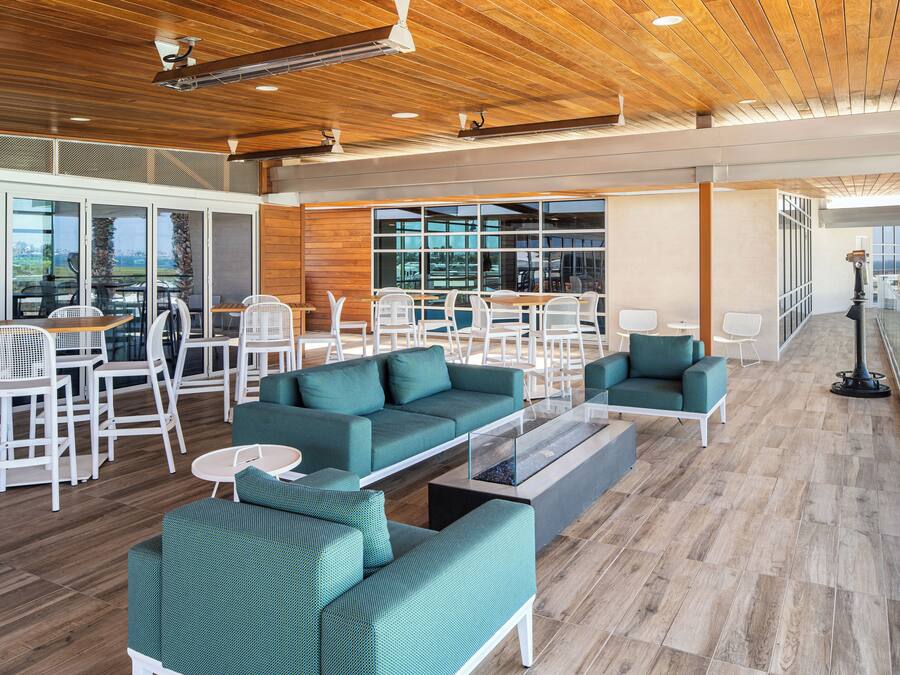 Un amplio salón con muebles modernos, ventanas grandes y vistas a la ciudad.