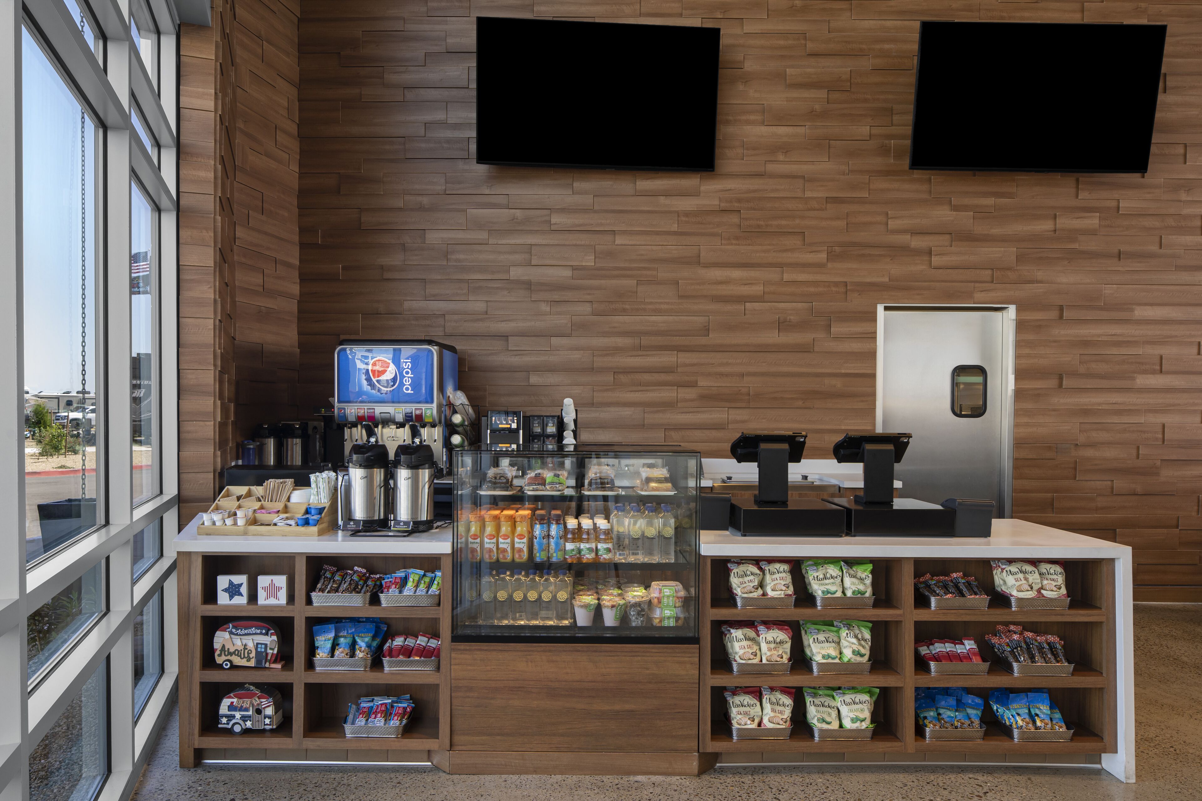 En modern inredning för ett kafé, med en kaffemaskin, vitrinskåp och en kassaapparat.