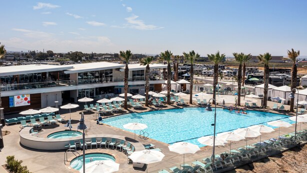 Un hôtel doté d’une grande piscine, de nombreuses chaises longues et de parasols.