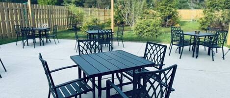 Un patio al aire libre con varias mesas y sillas.