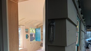 A bedroom with a bed, a window, and a thermostat on the wall. - Quintessential Carmel Writer's Hideaway with Private Garden and Patio. (Carmel-by-the-Sea)