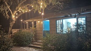 A house with a porch, string lights, and a tree. - Quintessential Carmel Writer's Hideaway with Private Garden and Patio. (Carmel-by-the-Sea)