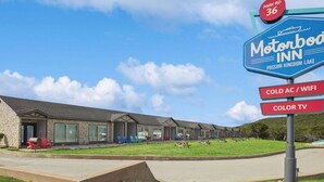 A Motor Inn with a sign indicating amenities like cold AC, WiFi, and color TV. - MotorBoat Inn Suite 1 Pet Friendly (Graford)
