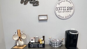 Disposición de una barra de café con una máquina de café, tazas y letrero de barra de café.