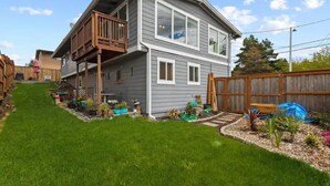 A two-story house with a balcony, a well-maintained lawn, and a wooden fence. - Exquisite Comfort: Luxury Suite (Portland)