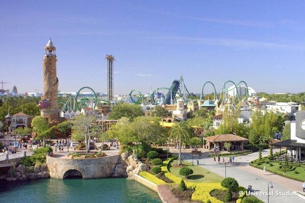 Un parc d’attractions proposant diverses attractions, notamment une haute tour et des montagnes russes.